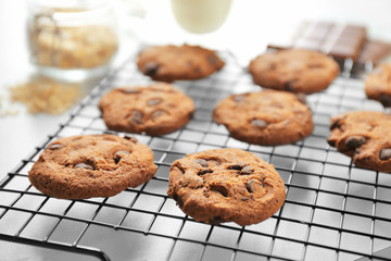Delicious oatmeal cookies with chocolate chips on metal grid, close up