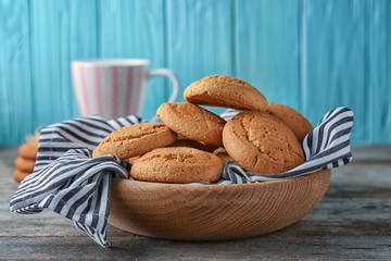 Bowl with delicious oatmeal cookies on wooden table