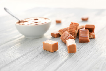 Tasty caramel candies on wooden table