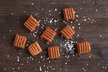 Salted caramel candies on wooden table
