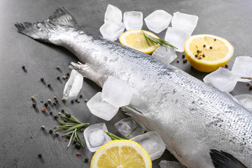 Fresh raw salmon, ice cubes and lemon on table, closeup