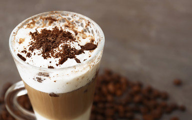 Glass with latte macchiato on grey background