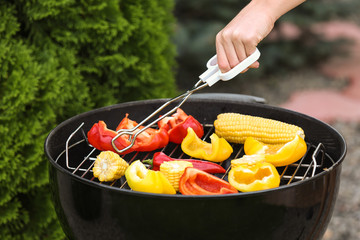 Chef cooking tasty vegetables on barbecue grill, closeup