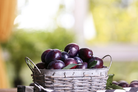 Fresh plums in wicker basket