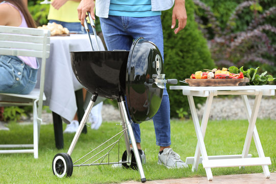 Man cooking tasty food on barbecue grill, outdoors