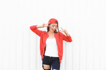 Attractive hipster girl posing near white wall