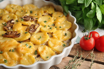 Baking dish with potato casserole on table