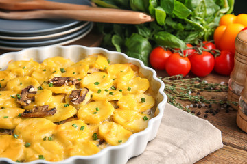 Baking dish with potato casserole on table