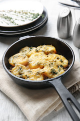 Frying pan with potato casserole on table