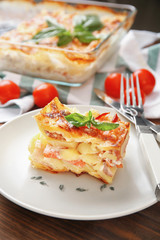 Plate with potato casserole on table
