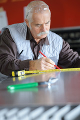 senior man installing and measuring a shower box at home