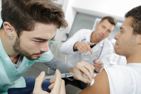 young doctor doing injured man tetanus toxoid injection