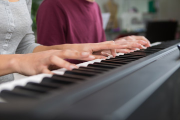 Fototapeta na wymiar playing piano four hands close-up