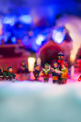 Fototapeta na wymiar Miniature festive background, Fairytale scenery with snowman holding star Singing In Choir Together. Miniature Christmas Village. Christmas concept,