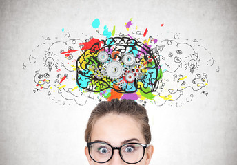 Astonished girl in round glasses, brain cogs