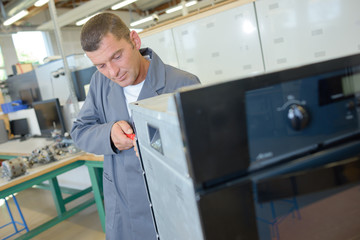 Repairman mending oven