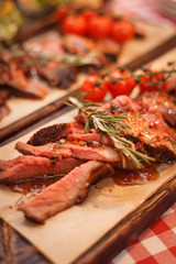 Roast beef with tomatoes and spices on the boards
