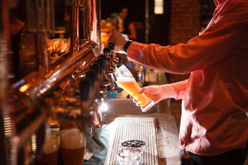 Obrazy na Szkle  Nalewanie jasnego piwa z kranu w barze