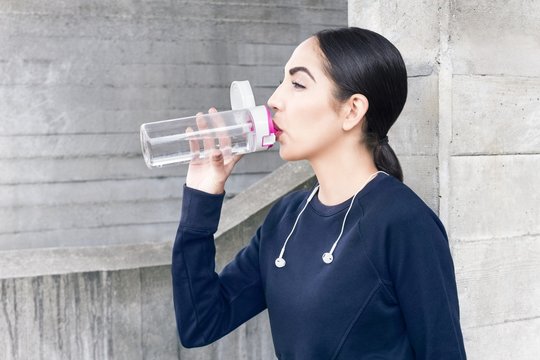 MODEL RELEASED. Young woman drinking water from bottle.