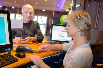 man is paying using payment terminal and entering pin