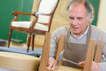portrait of happy senior worker sitting in his workshop