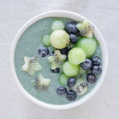 Blue spirulina smoothie bowl with melon, kiwi fruit and blueberries