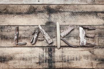Lake sign made of driftwood on a wooden background