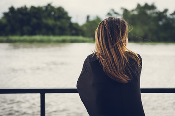 Lonely woman sitting and looking at the river