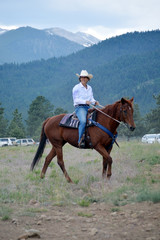 Middle-Aged Cowgirl on Brown Horse