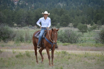 Middle-Aged Cowgirl on Brown Horse