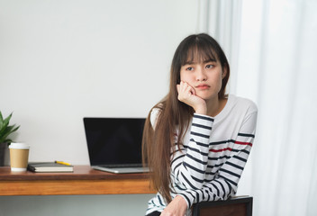 asia woman bored about working at cafe restaurant,Female rest chin on hand with stress feeling with laptop and coffee cup on table in coffee shop,Boring work concept