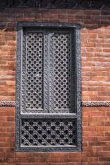 wooden traditional handcrafted window in the brick wall