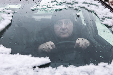 Driver looking through a foggy and snowy car window, soft focus through glass.