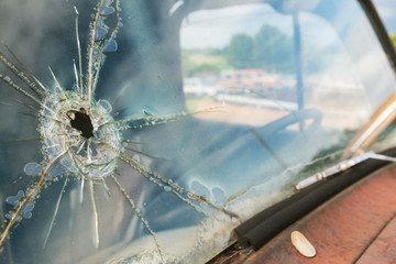 Windshield Of Junkyard Vehicle Has Hole And Cracks In Glass
