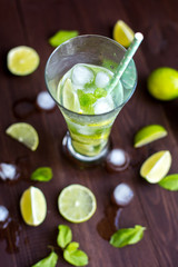 Chilled delicious lemonade in a glass. Traditional mojito with water, ice, lime, mint. Alcohol-free.