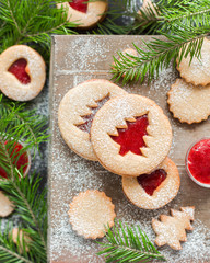 Obraz na płótnie Canvas Christmas baking. Homemade cookies with strawberry jam in the form of Christmas trees on a wooden background. Christmas food. New Year card. Rustic style.