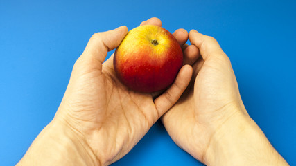 A man's hand holds an apple