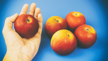 A man's hand holds an apple