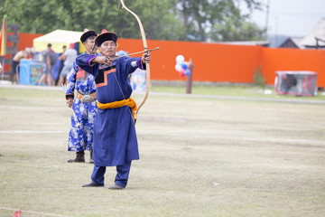 Young man shoots from a sports bow