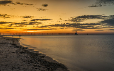 Fototapeta na wymiar Lighthouse by the beach at sunset sky on Lake Michigan, Indiana, USA.