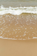 Smooth sandy beach and small wave on a sunny day in the summer.