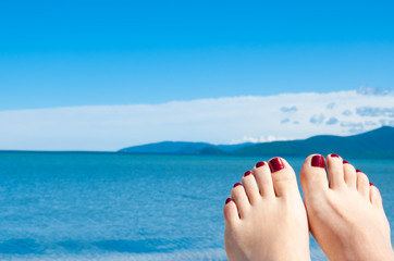 womans feet against sea and blue sky