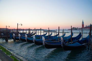 Fototapeta na wymiar The moored gondolas at San-Marko Embankment at sunrise. Venice, Italy
