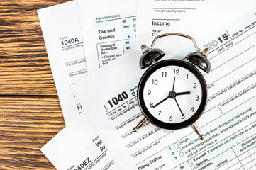 Tax forms with clock on the table. Top view. Business and tax concept.