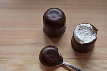 chocolate marsh-mallow whit silver spoon on light wooden background