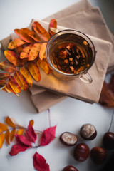 Autumn photography with books, a cup of tea, fallen yellow leaves, chestnuts. On the windowsill are books and a cup of tea. Window after the rain. A card with a place for your text.