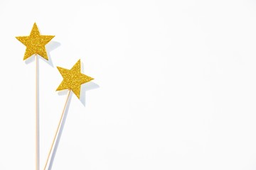 Two golden party magic wands on a white background. Copy space.