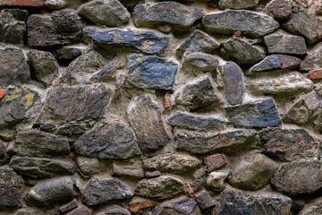 Medieval wall built of stone and bricks, background texture