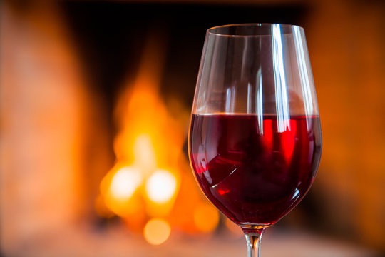 Glasse of red wine on the background of fire