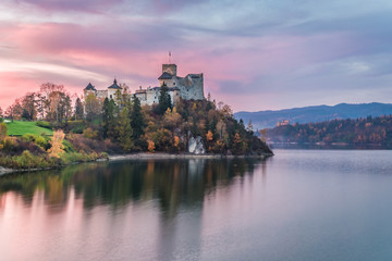 Fototapeta na wymiar Wonderful castle by the lake at dusk in autumn